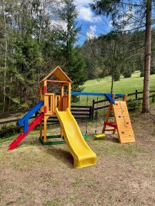 un parque infantil con tobogán y estructura de juegos en Chalet Durik Bystra-Jacuzzi-Sauna-Kids playground-Fire pit-Hiking, en Horná Lehota