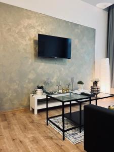 a living room with a table and a tv on a wall at SOFI living in Ostrava