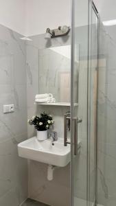 a white bathroom with a sink and a shower at SOFI living in Ostrava