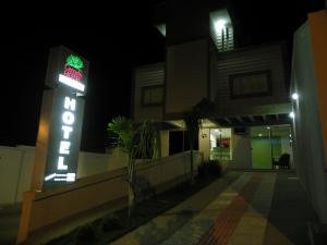 a neon sign in front of a building at night at Cerrado Hotel LTDA in Campo Grande