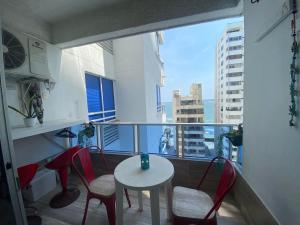 uma varanda com uma mesa e cadeiras e uma janela em Hermoso apartamento frente al Mar Caribe em Cartagena das Índias