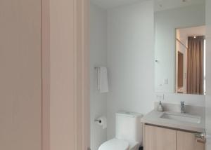 ein Badezimmer mit einem WC, einem Waschbecken und einem Spiegel in der Unterkunft Junior Suite DLX Aeropuerto in Echeverría