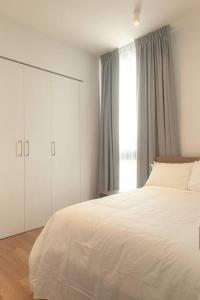 ein Schlafzimmer mit einem weißen Bett und einem großen Fenster in der Unterkunft Junior Suite DLX Aeropuerto in Echeverría