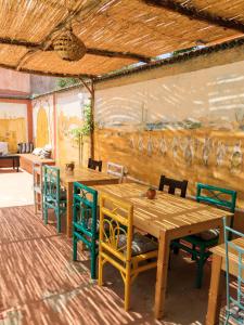a dining room with a wooden table and chairs at Kasbari House in Taghazout +61 photos