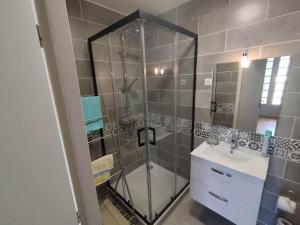 W łazience znajduje się szklana kabina prysznicowa i umywalka. w obiekcie La Maison de Raph w mieście Villeneuve dʼOlmes