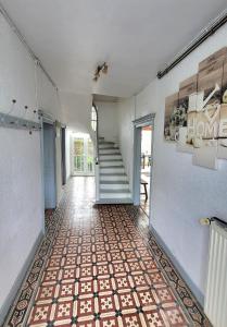 a hallway with a staircase and a tile floor at Gite de la Fontaine in La Bazouge-des-Alleux