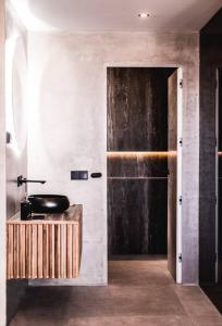 ein Bad mit einem schwarzen Waschbecken und einer Tür in der Unterkunft Portside Suite Banus in Marbella