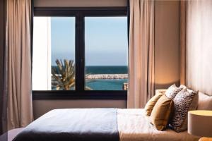 Schlafzimmer mit einem Bett und Meerblick in der Unterkunft Portside Suite Banus in Marbella