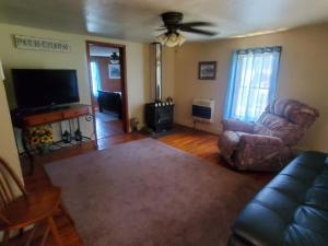 een woonkamer met een bank en een flatscreen-tv bij Kentucky Hills Country Cottage in Morgantown