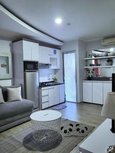a kitchen and living room with a couch and a table at Apartment Kalibata City by PanBul in Jakarta