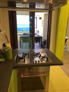 a kitchen with a stove with a view of the ocean at DHOME Baia Mazzaro' in Taormina
