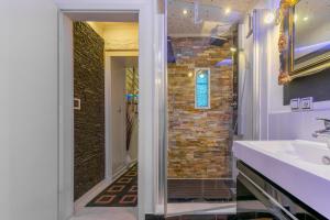 baño con lavabo y pared de ladrillo en Apartments Villa Tomaš, en Brela