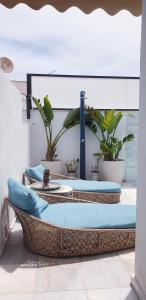 Apartamento MarySol B con Terraza y Piscina privada في بينالمادينا: مجموعة من ثلاثة أسرة في غرفة بها نباتات