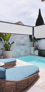 ein Pool mit zwei Korbstühlen neben einem Pool in der Unterkunft Apartamento MarySol B con Terraza y Piscina privada in Benalmádena