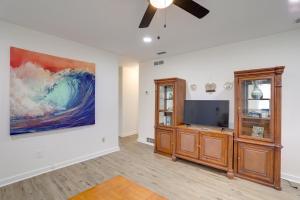a living room with a tv and a painting on the wall at Clearwater Vacation Rental Near Downtown and Beaches in Clearwater