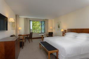 um quarto de hotel com uma cama, uma mesa e cadeiras em Sheraton Carlton Nuernberg em Nurembergue