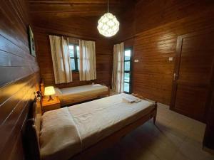 a bedroom with two beds in a wooden room at Koilani Village House in Koilani