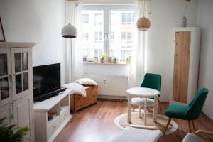 - un salon avec une télévision, une table et des chaises dans l'établissement Zentral Bahnhof Apartment# Ntfx#, à Halle-sur-Saale