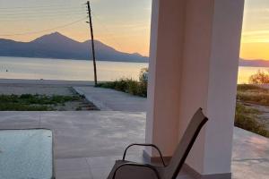 a chair sitting on a porch with a view of the ocean at Bay-dream 3 in Adamantas