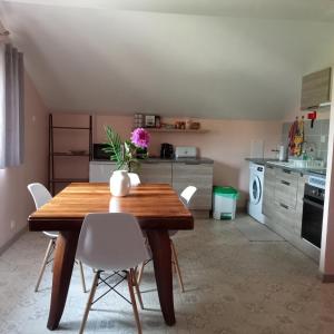 una cucina con un tavolo di legno e sedie bianche di Alojamento Local - Casa Amarela ad Alvaiázere