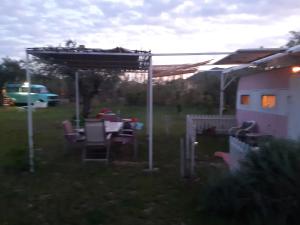 a table and chairs under a pergola in a yard at Mary 's Retro Caravan in Eratini
