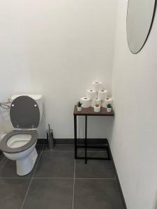 La salle de bains est pourvue de toilettes et d'une table avec du papier toilette. dans l'établissement La movida, à Lattes
