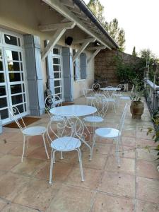 a group of tables and chairs on a patio at La Bourdette - Elegantes Herrenhaus im Boutique Stil in Daumazan-sur-Arize
