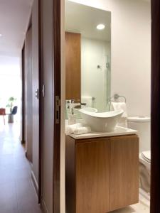 een badkamer met een wastafel en een spiegel bij New apartments in building with pool, rooftop and gym in Condesa in Mexico-Stad