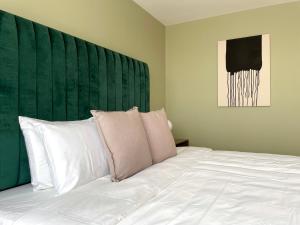 een slaapkamer met een groot wit bed met een groen hoofdeinde bij New apartments in building with pool, rooftop and gym in Condesa in Mexico-Stad +19 foto's