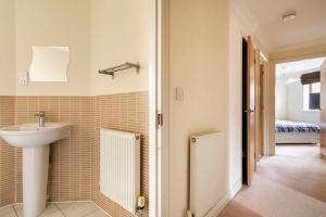 a bathroom with a sink and a mirror and a bedroom at 2 Beds Broughton Apartment in Broughton