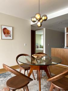 een eetkamer met een glazen tafel en 2 stoelen bij New apartments in building with pool, rooftop and gym in Condesa in Mexico-Stad
