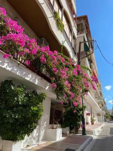 a building with pink flowers on the side of it at Eleni Penthouse Loutraki in Loutraki