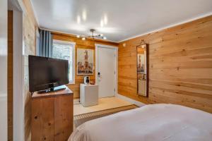 1 dormitorio con paredes de madera y TV de pantalla plana en Ruschmeyers Hotel, en Montauk