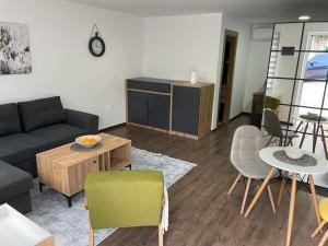a living room with a couch and a table and chairs at Damade apartments in Jajce