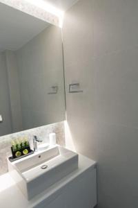 ein weißes Badezimmer mit einem Waschbecken und einem Spiegel in der Unterkunft Modern apartment close to Athens city center (Form_F2) in Athen
