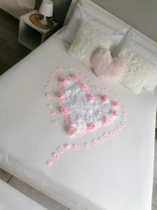 a white bed with a heart made out of roses at IL CILIEGIO DI ZOE in Cerro Lago Maggiore