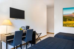 a hotel room with a desk with a bed and a television at Hotel Anna Siena Nord in Siena