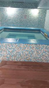 a swimming pool with a tiled floor and a tile wall at Belvedere Holidey Clab apartament L403 in Bansko