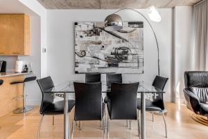 Les Immeubles Charlevoix - Le 760309 في مدينة كيبك: غرفة طعام مع طاولة زجاجية وكراسي سوداء
