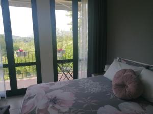 a bedroom with a bed with a view of a balcony at IL CILIEGIO DI ZOE in Cerro Lago Maggiore