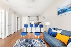 a living room with a blue couch and blue stools at Elegant & Luxurious Modern Apartment with Southern Charm in Fort Worth