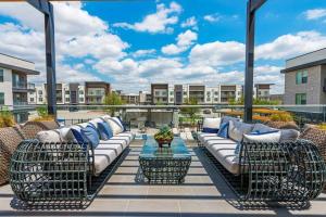 a patio with couches and a table on a balcony at Elegant & Luxurious Modern Apartment with Southern Charm in Fort Worth