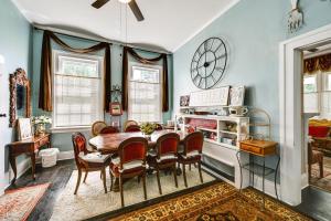 uma sala de jantar com mesa e cadeiras e um relógio em Historic Home with Yard Near High Point University em High Point