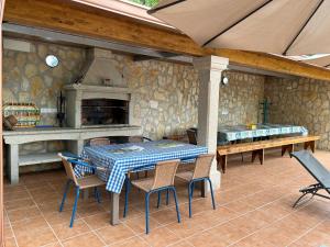 un patio con mesa, sillas y chimenea en Villa Vazquez Sanxenxo La Lanzada, en Balea