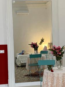 een spiegel in een kamer met een tafel en stoelen bij Casa di Rita in Catania
