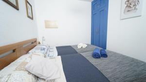 una camera da letto con un letto e pantofole blu di Apartamento Brisa Del Mar ad Almuñécar