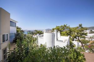 a white building with trees in front of a building at Enchanting House with Backyard in Bodrum in Bodrum City