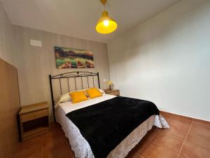 a bedroom with a bed with two yellow pillows at Villa Vazquez Sanxenxo La Lanzada in Balea