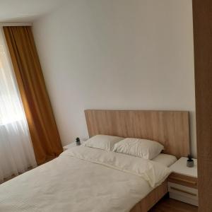 1 dormitorio con cama blanca y cabecero de madera en Apartment Deluxe, en Peje