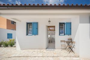 Cette maison blanche dispose de volets bleus et d'une terrasse. dans l'établissement Spacious holiday house in Istria, à Peroj
